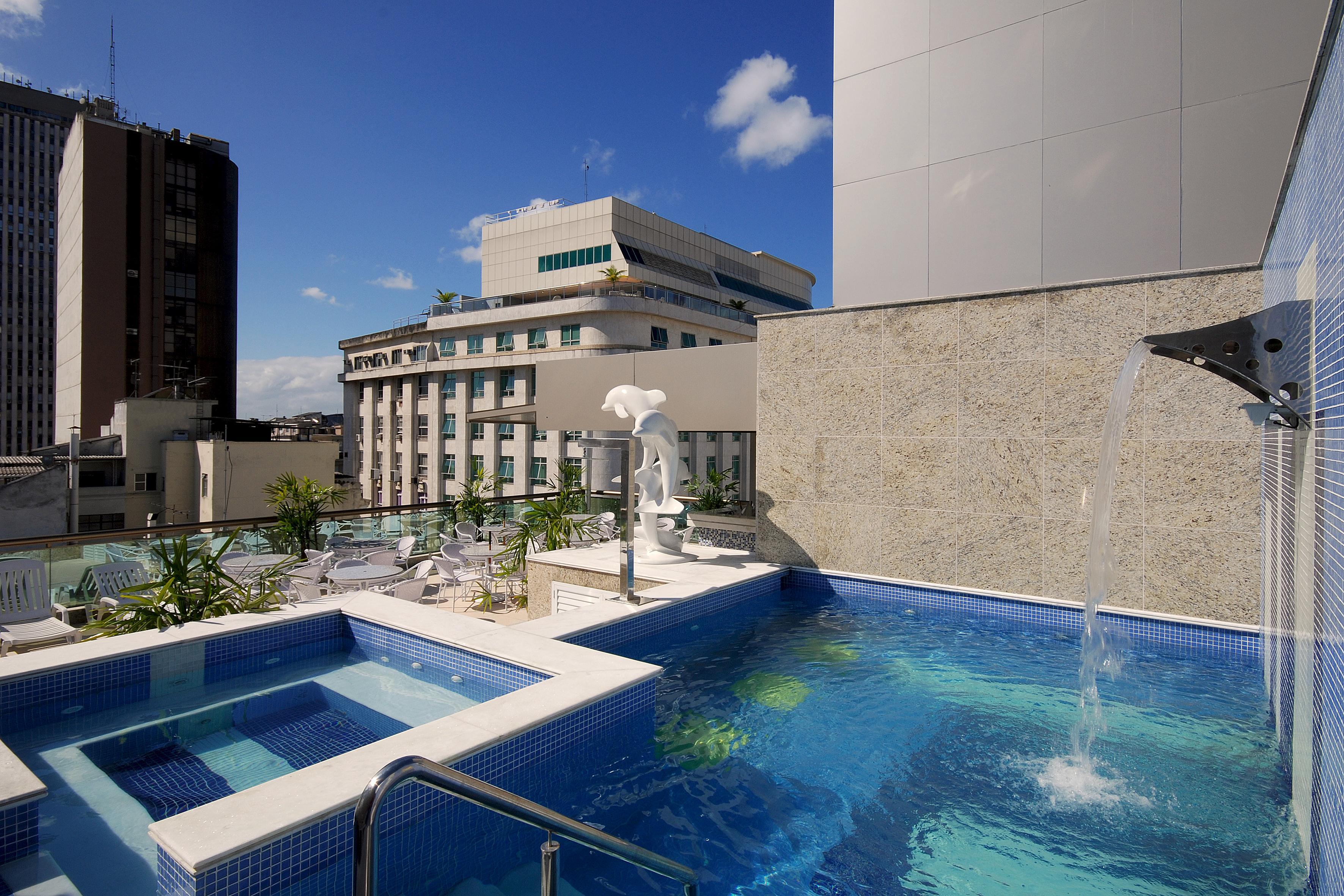 Hotel Atlantico Business Centro Rio de Janeiro Eksteriør bilde The photo shows a rooftop area featuring a swimming pool and a spa. The pool is inviting with a clear blue water, and there appears to be a waterfall feature. Surrounding the pool are areas for relaxation, possibly with sun loungers. In the backgroun