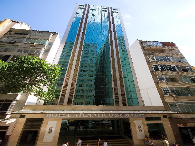 Hotel Atlantico Business Centro Rio de Janeiro Eksteriør bilde The photo shows a modern hotel building, likely a high-rise, with a glass facade that reflects the sky. The hotel appears to have multiple stories, with vertical lines and a sleek design. At the base of the building, there is a sign that reads "Hotel
